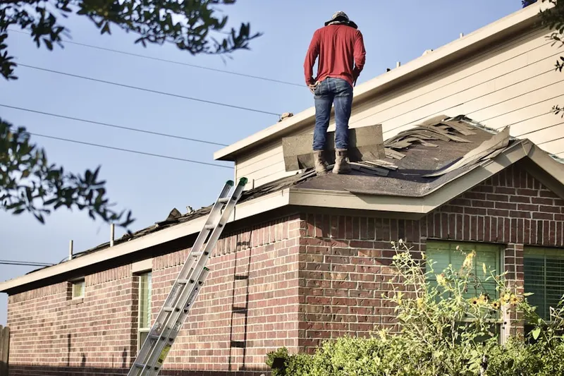 Professional roofer working on a residential roof in Coaldale